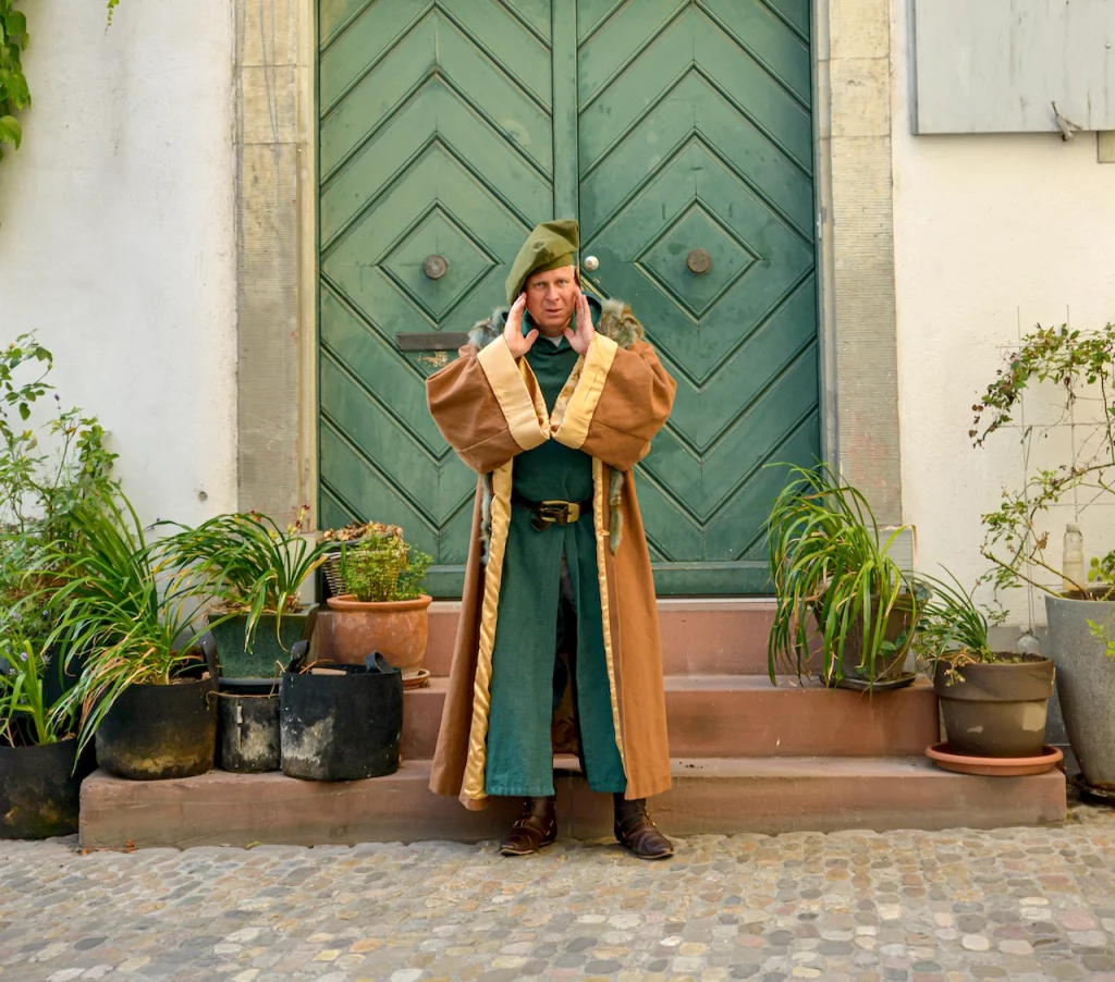 Wigand Neumann in der Rolle des Erasmus von Rotterdam bei einer schauspielerischen Stadtfuehrung in der Altstadt von Basel vor einer alten Tuer