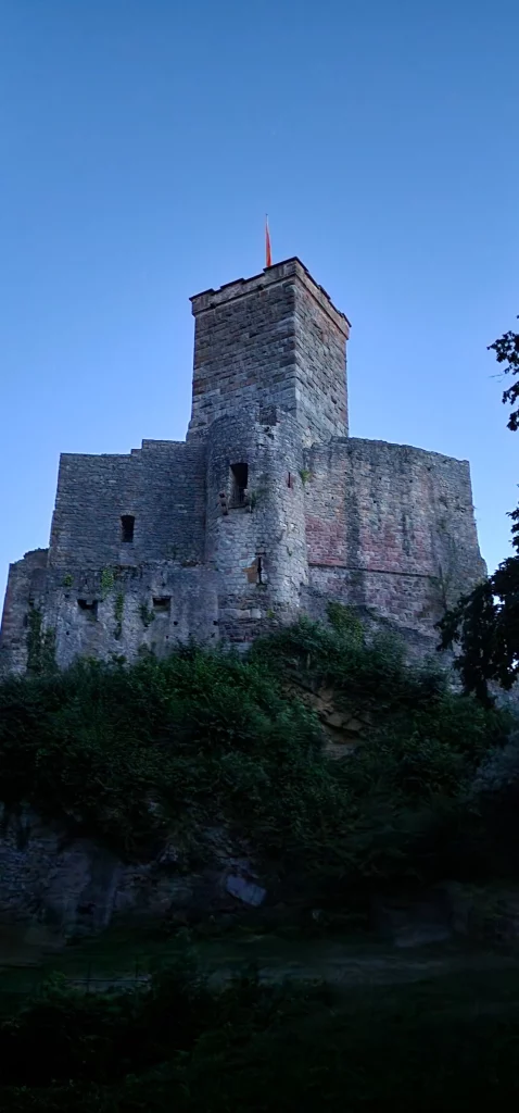 Blick von unten auf Burg Roetteln bei Daemmerung Gruselfuehrung Schauspielfuehrung von Wigand Neumann in der Rolle als Ritter