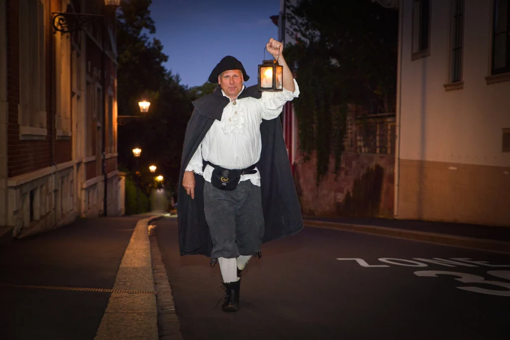 Wigand Neumann in der Rolle des Nachtwaechters bei einer naechtlichen schauspielerischen Stadtfuehrung im St. Alban Tal in Basel laeuft durch die dunkle Strasse mit einer Laterne