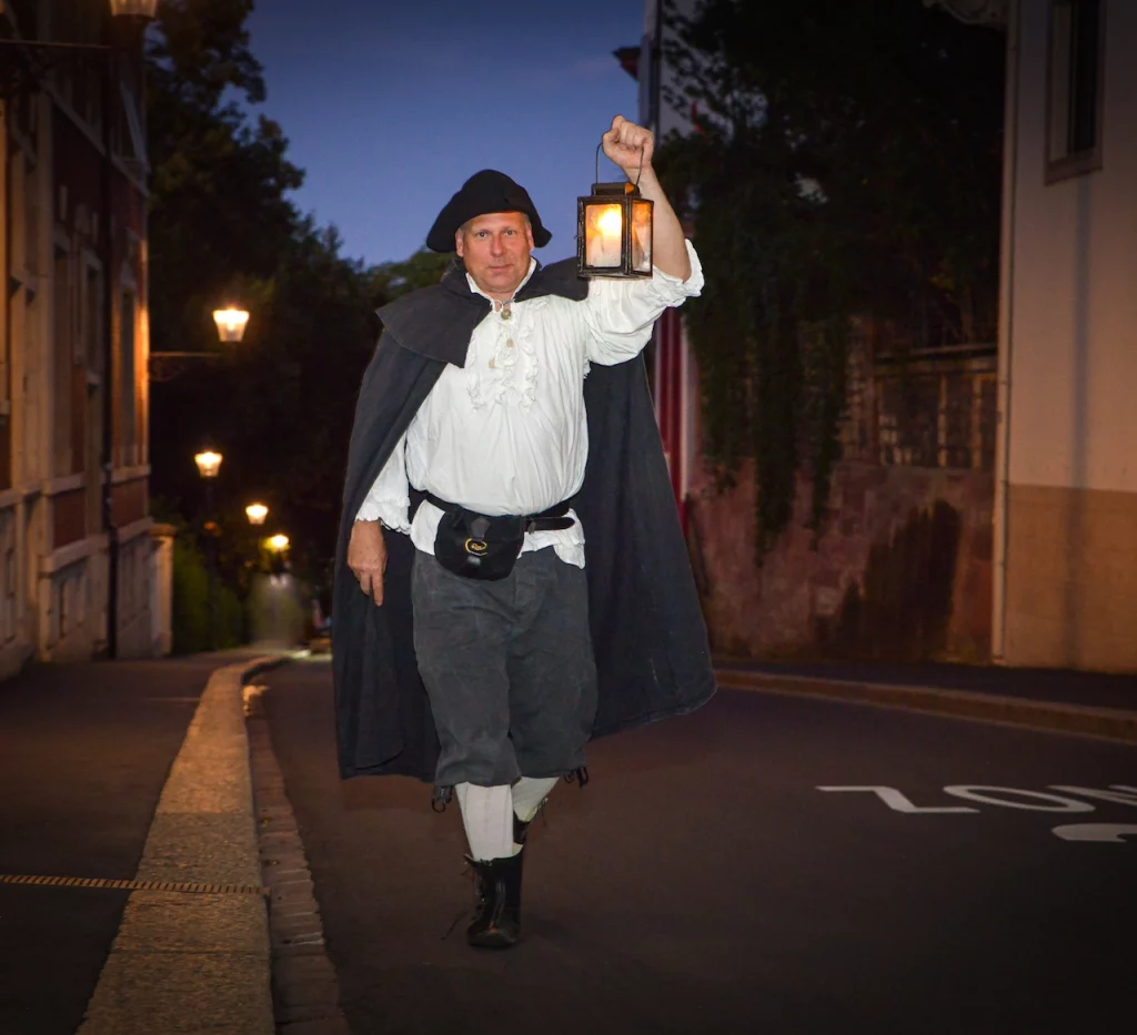 Wigand Neumann in der Rolle des Nachtwaechters bei einer naechtlichen schauspielerischen Stadtfuehrung im St. Alban Tal in Basel laeuft durch die dunkle Strasse