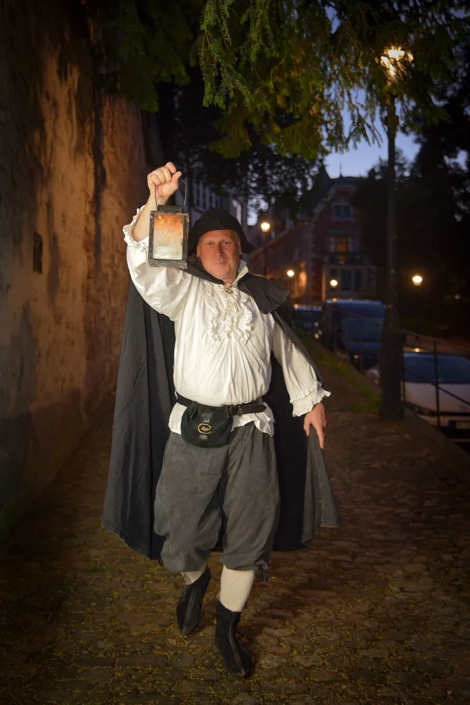 Wigand Neumann in der Rolle des Nachtwaechters bei einer naechtlichen schauspielerischen Stadtfuehrung im St. Alban Tal in Basel und haelt eine Laterne hoch fuer die Beleuchtung