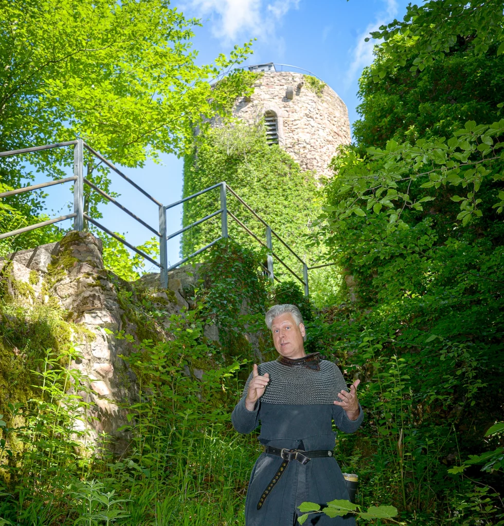 Wigand Neumann in der Rolle des Ritters Markgraf Wilhelm bei einer Schauspielfuehrung auf der Sausenburg mit Blick auf den Burgturm
