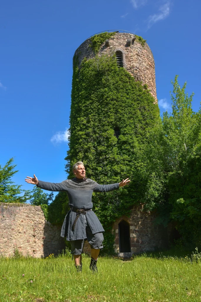 Wigand Neumann in der Rolle des Ritters Markgraf Wilhelm bei einer Schauspielfuehrung auf der Sausenburg mit Blick auf den Burgturm